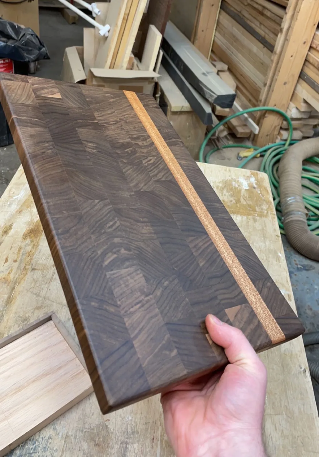 Walnut end grain cutting board with a light wood stripe
